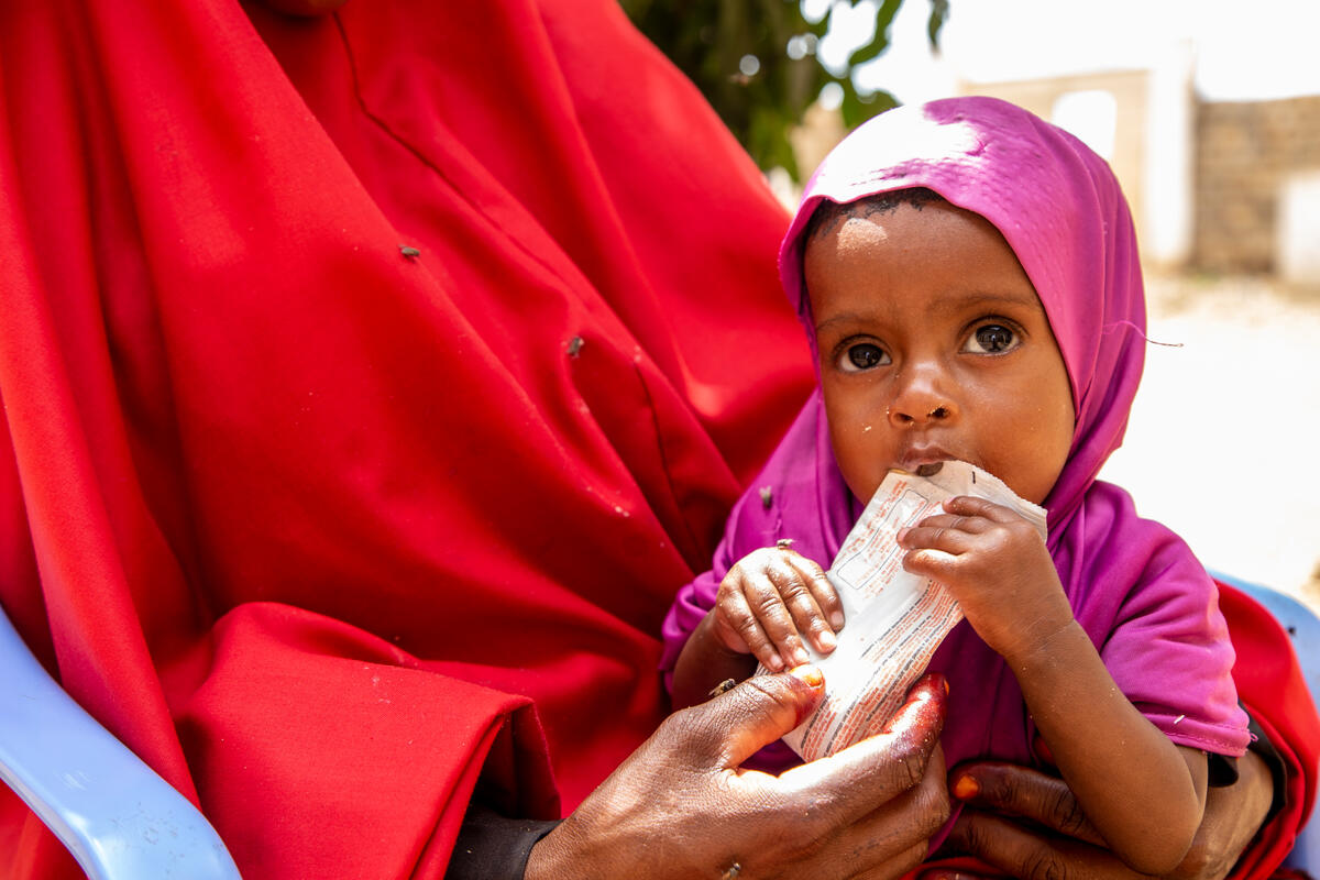 Somali baby eating on her mother's lap