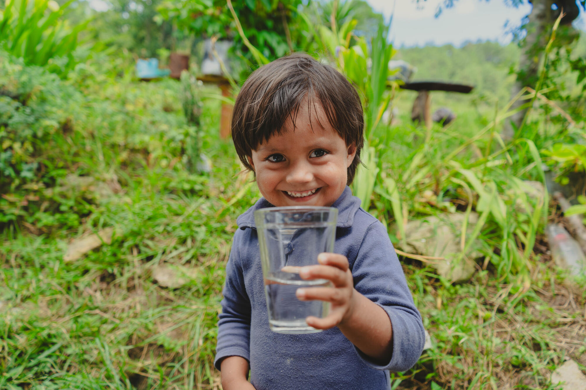 A child in Honduras holds a glass of clean water