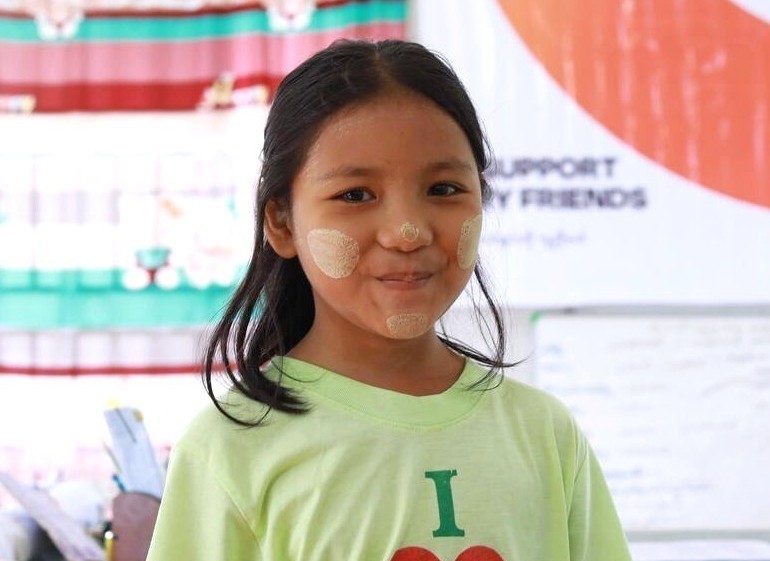Young girl smiling at the camera, in a WV Child Friendly Space in Myanmar.