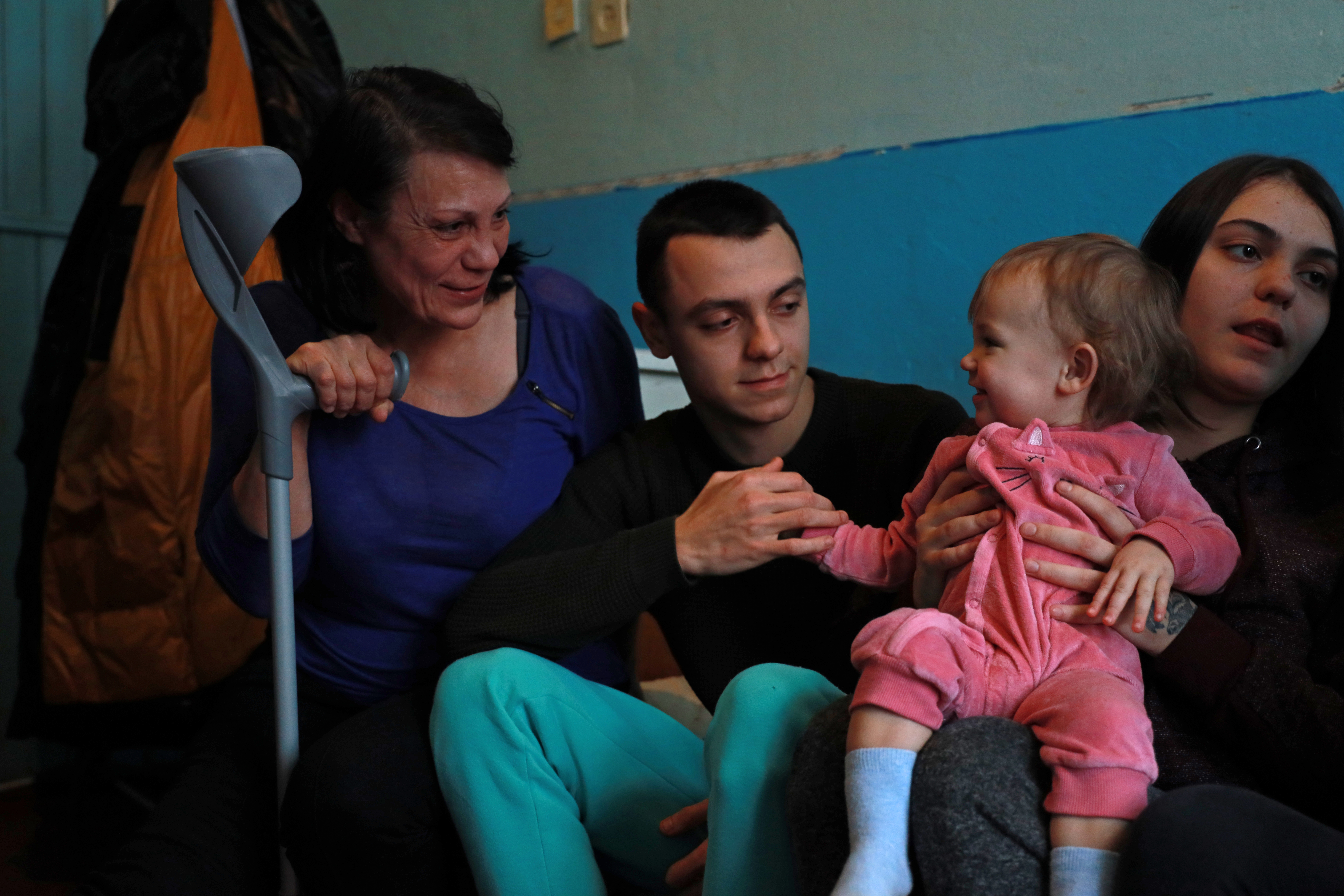 Three generations of a family sit together - grandmother, son and granddaughter