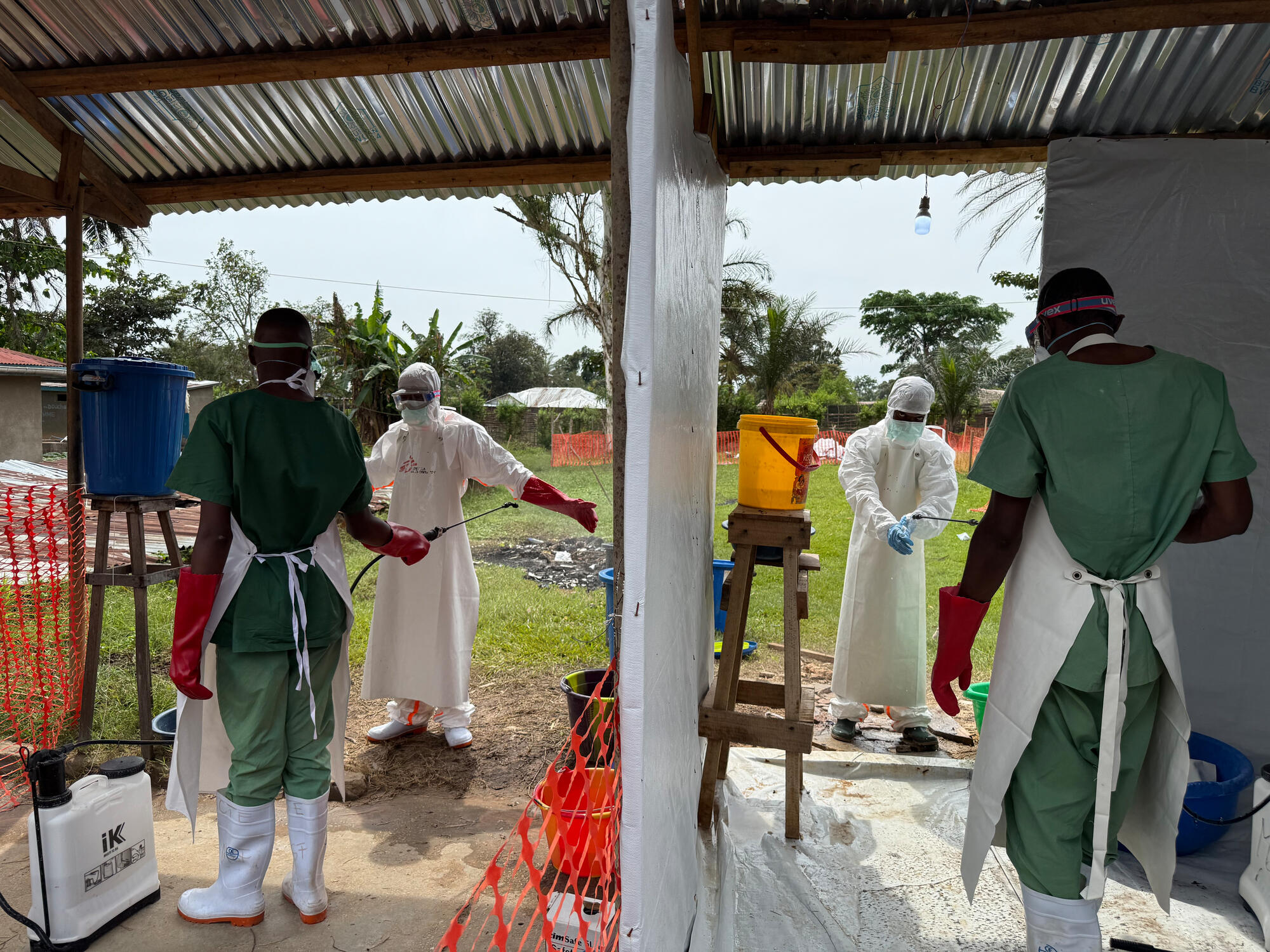 Health workers disinfect doctors after treating patients.