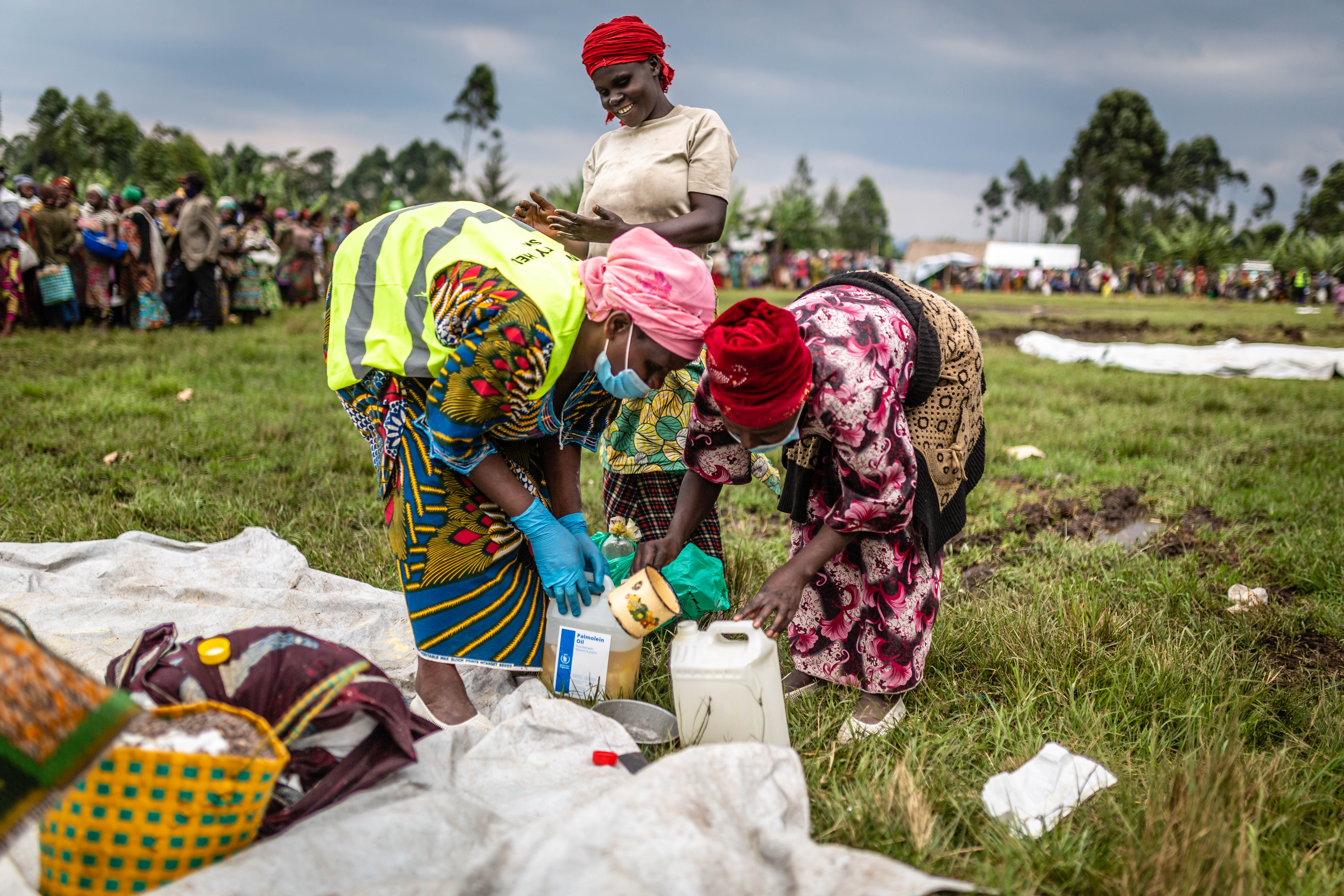 Three women collecting food supplies in DRC.