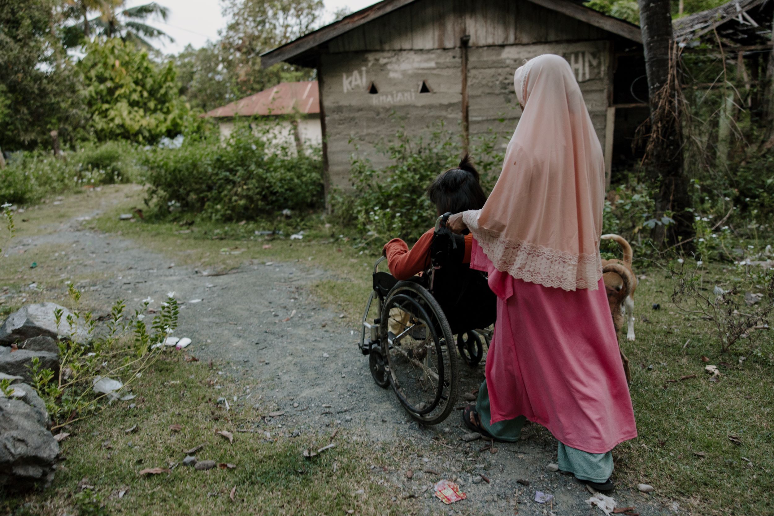 A mother pushing her daughter in a wheelchair