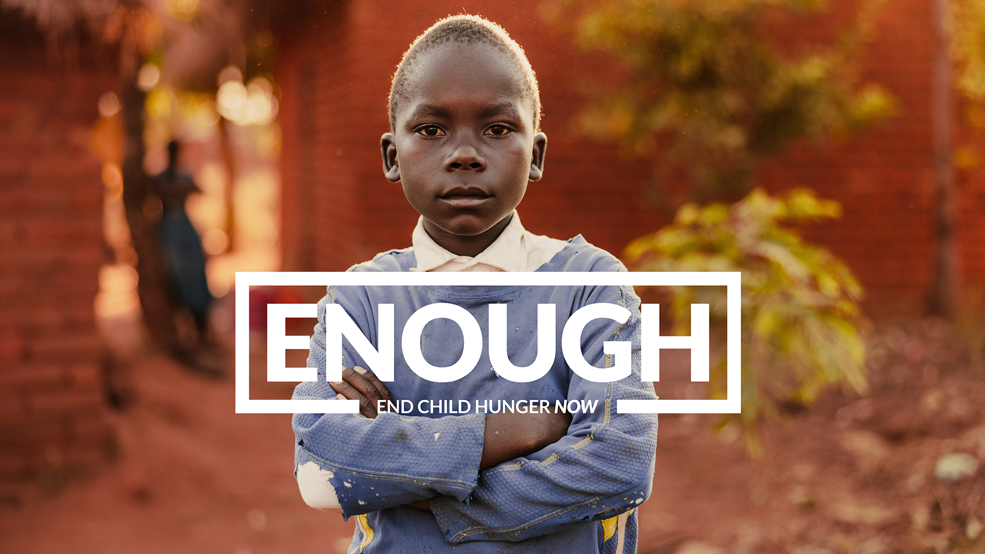 A boy looks to camera with his arms crossed
