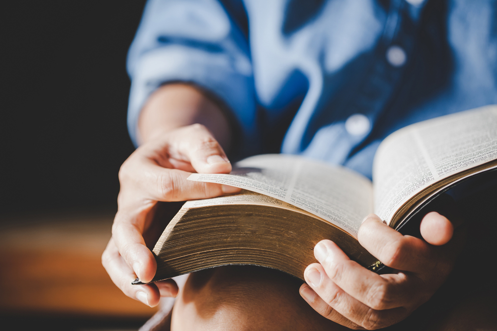 Person turning a page of the Bible