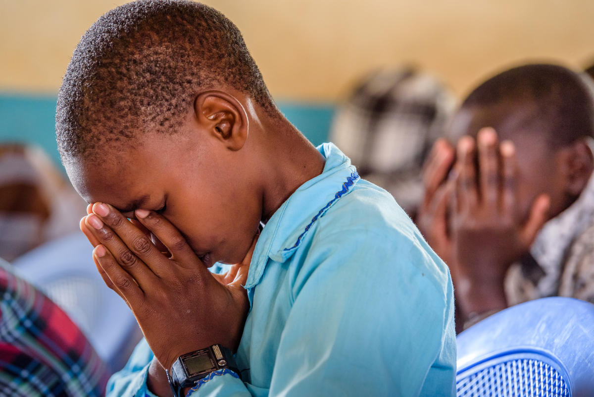 Child closing their eyes praying