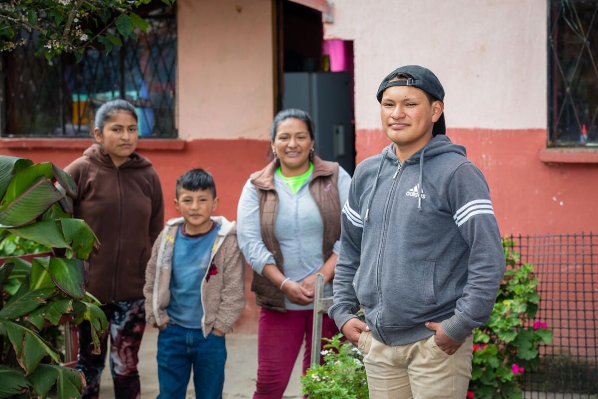 A family stand together outside their home in Ecuador