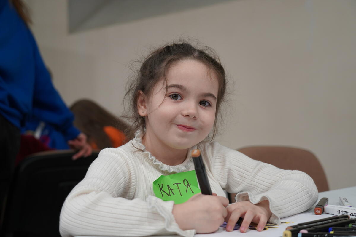 Girl in Ukraine smiles as she writes