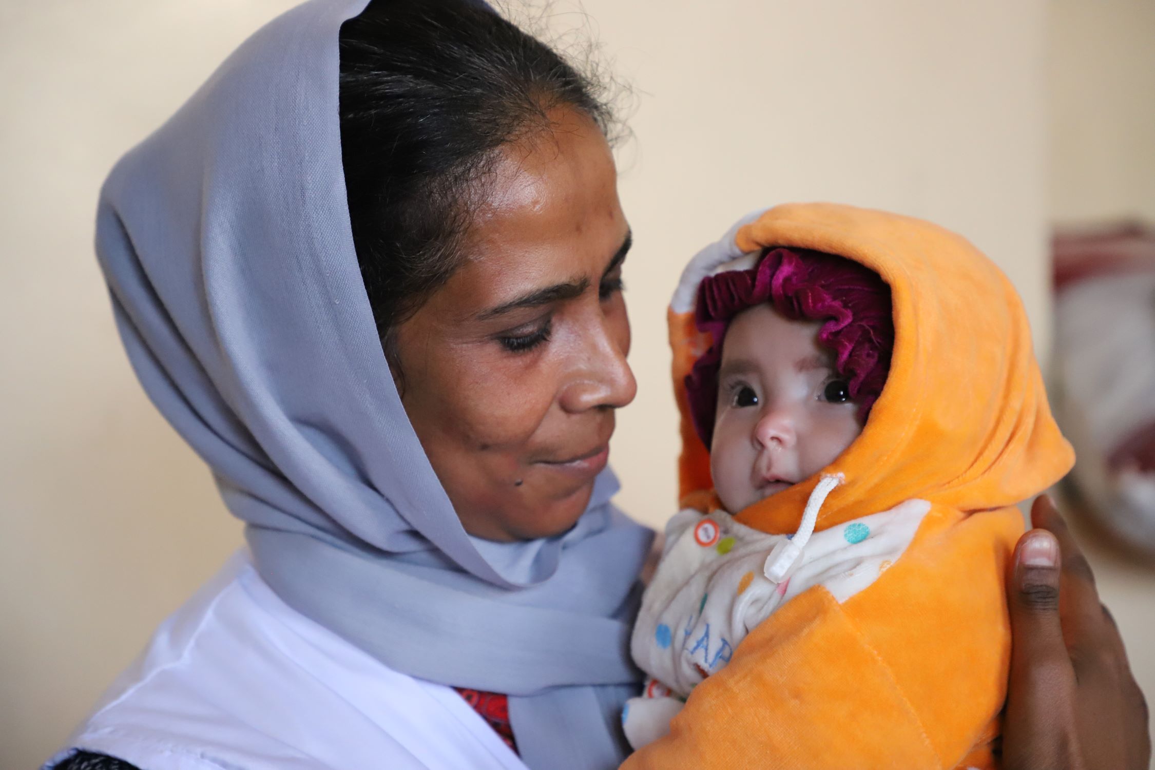 Asuntha Charles holds a young child who has undergone treatment through the health and nutrition programme.