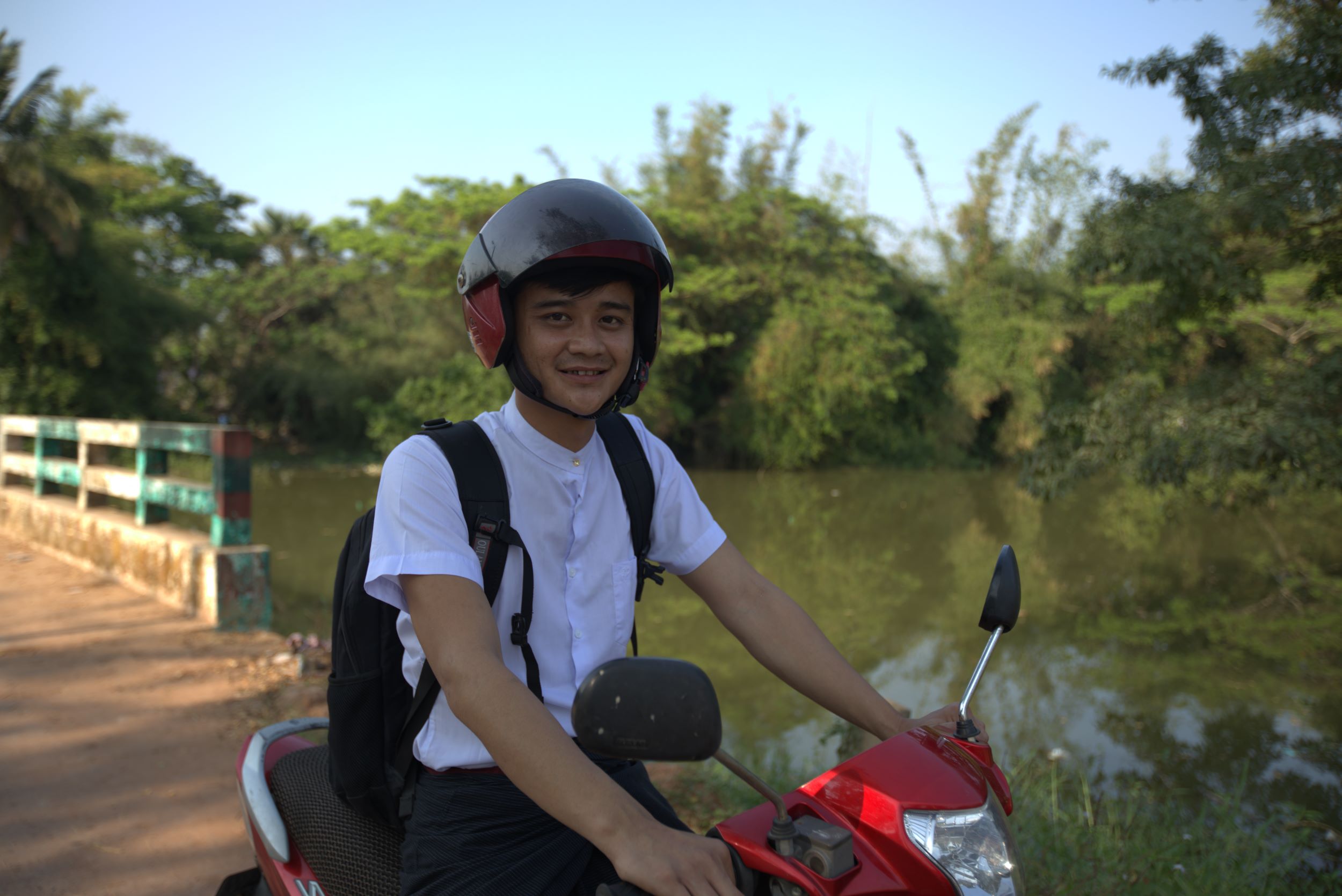 A young man sits on a moped.