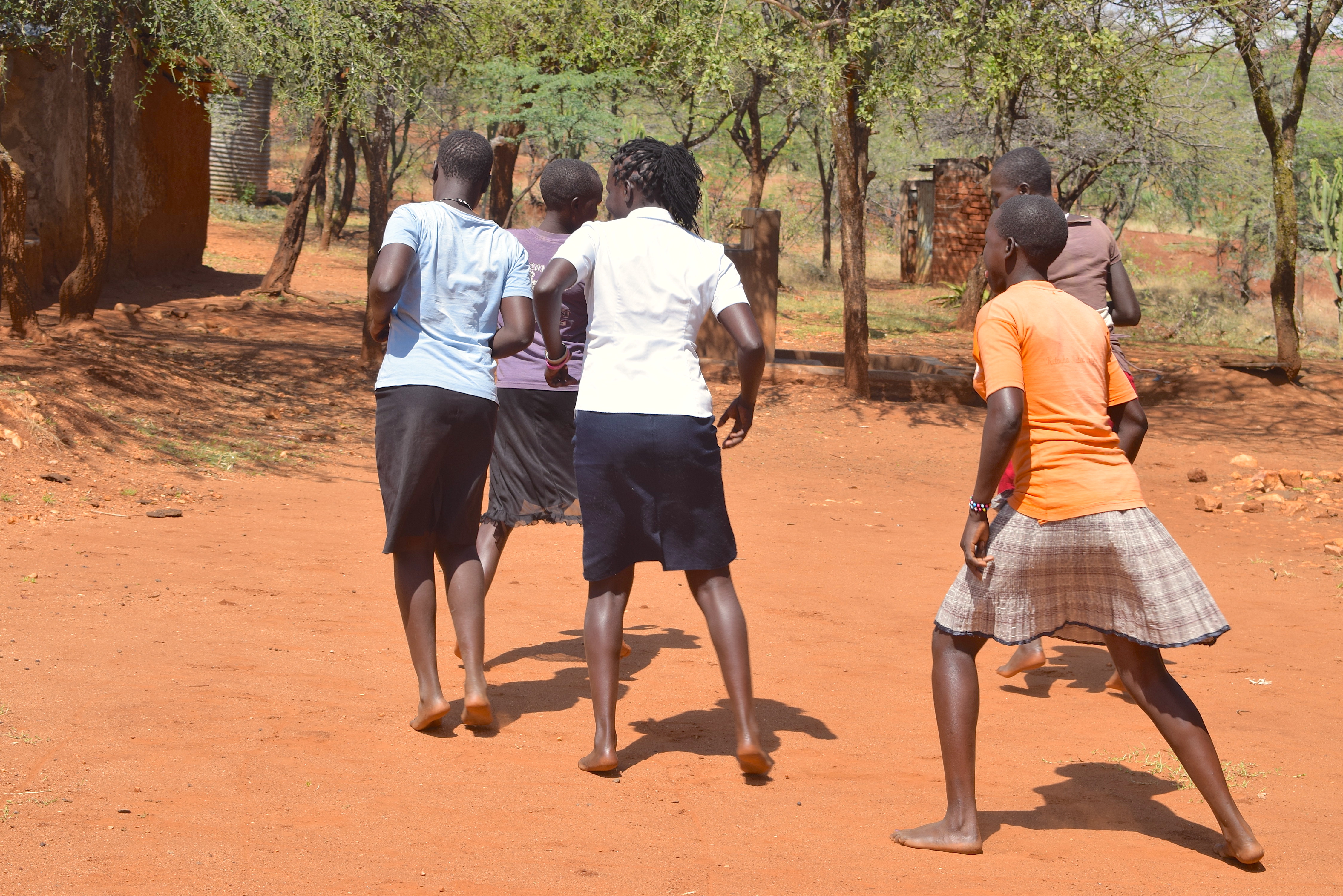 Four teenage girls playing happily outside