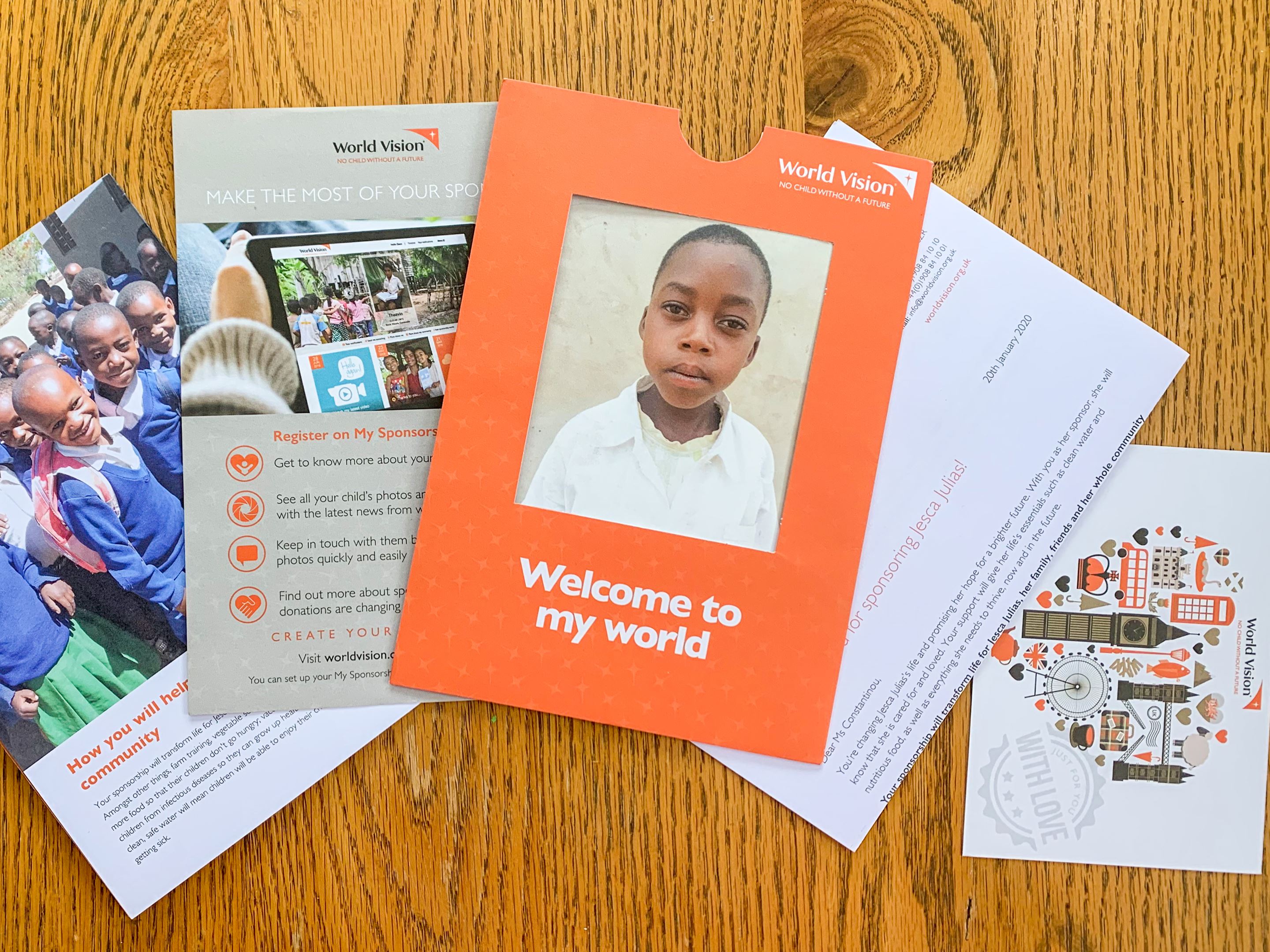 A Child Sponsorship Welcome Pack laid out on a table