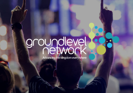 Man at event with hands raised in praise