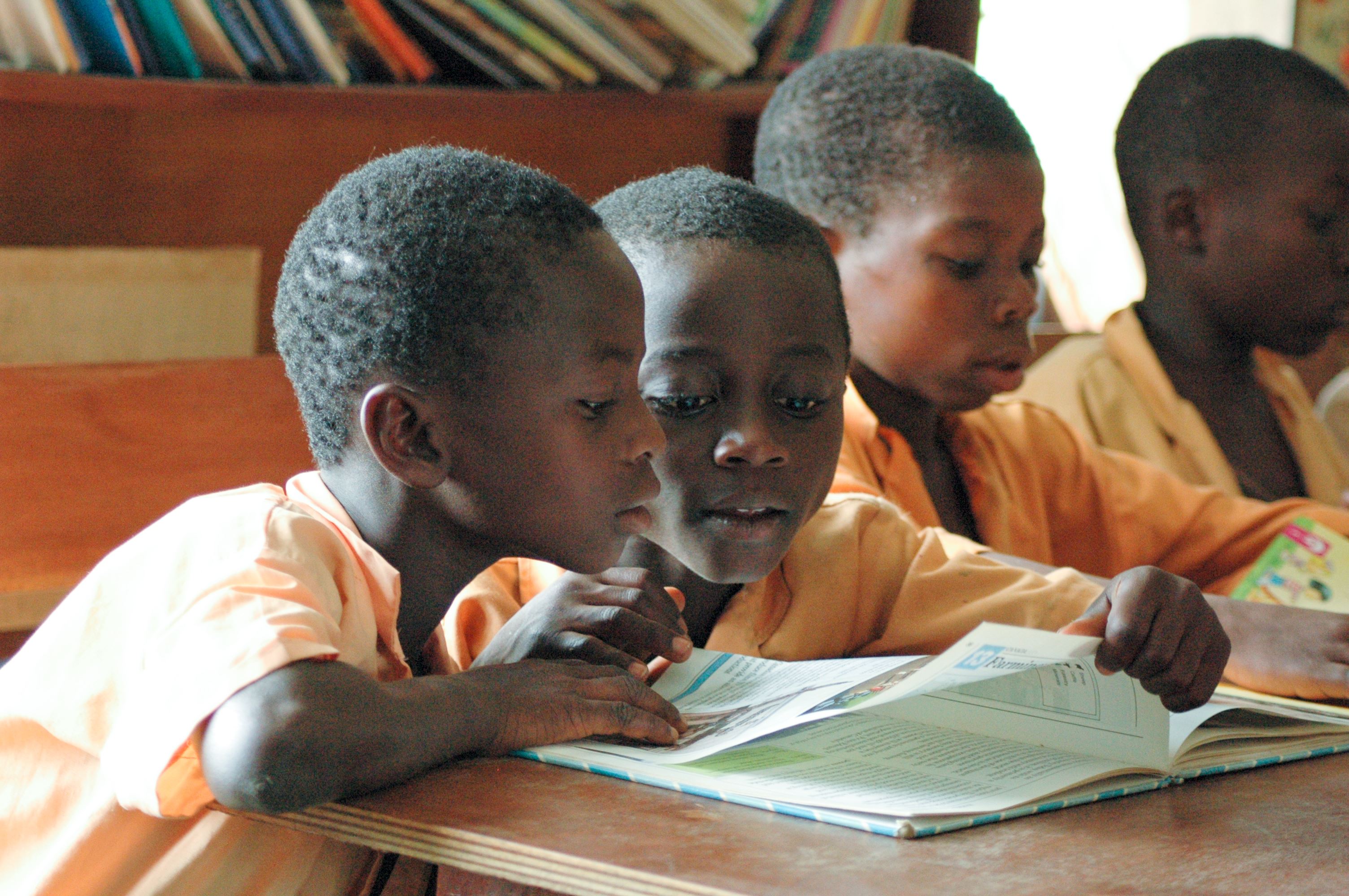 Two young children reading a book in school